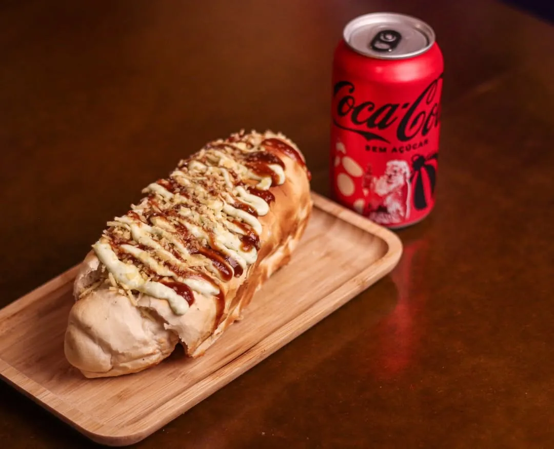 Lanche no pão com molhos servido na tábua, com refrigerante