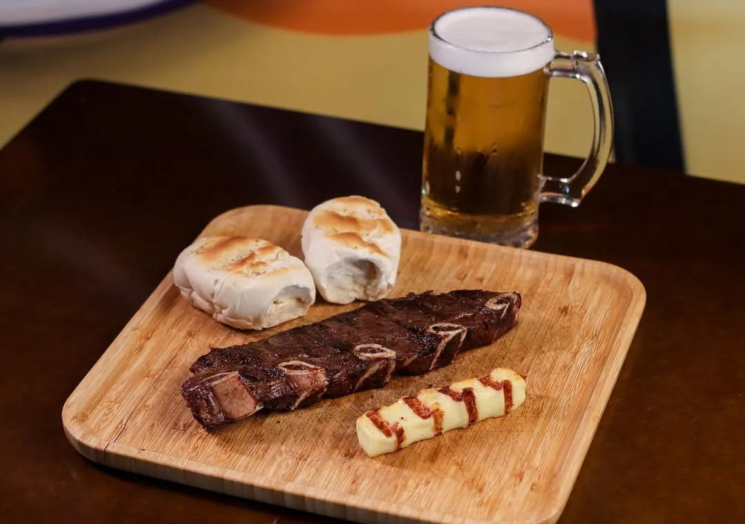 Carne na brasa com pão de alho, queijo coalho e chopp gelado